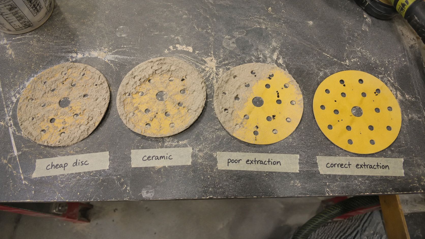 Technician checking a worn 150mm backing pad and interface pad before sanding.